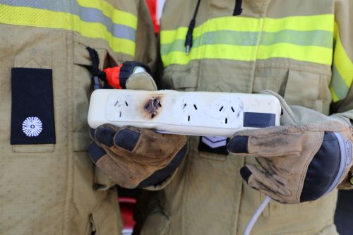A photo of firefighters holding a burnt powerboard